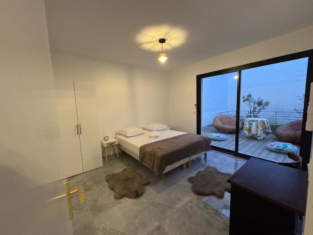 a bedroom with a bed and a large window at T2 modern - 10 min from Paris in Colombes