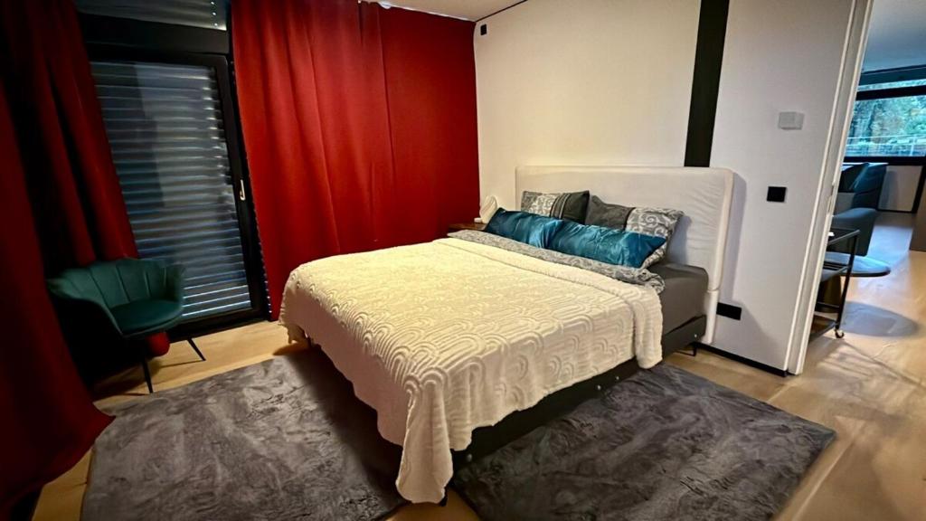 a bedroom with a bed and a red curtain at Nature Oasis near Berlin - Peaceful and Modern Stay in Falkensee