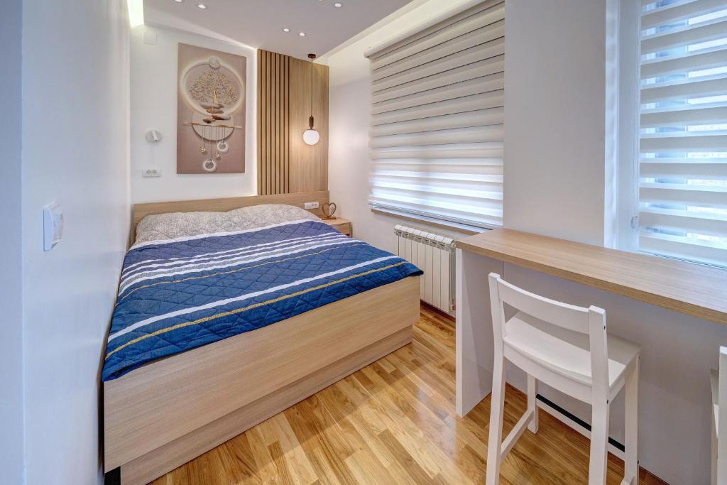a bedroom with a bed and a desk and a chair at Spa King Apartments 1 in Belgrade