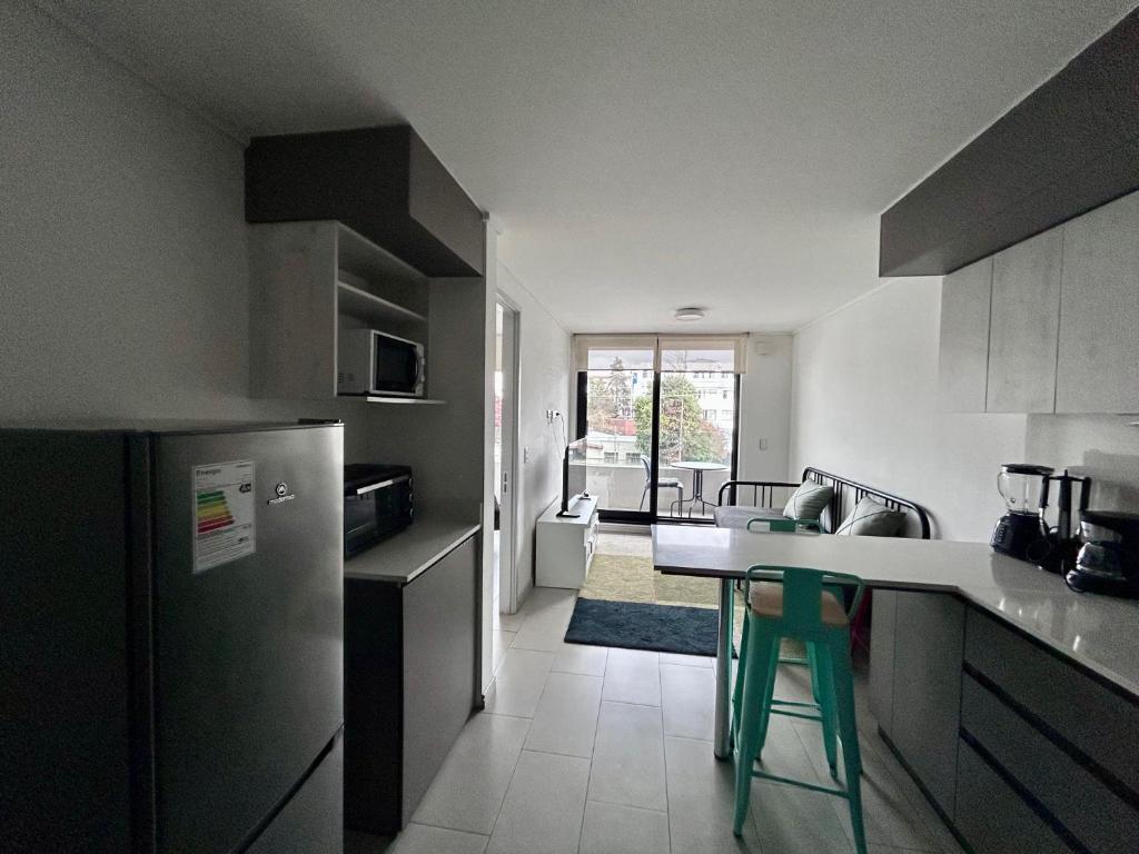 a kitchen with a refrigerator and a table in it at Departamento central, exclusivo in El Cerrillo