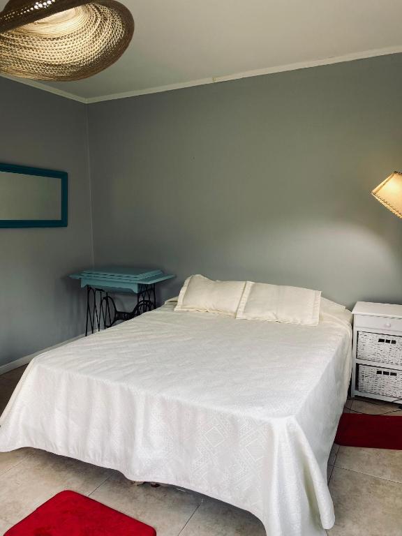 a bedroom with a white bed and a blue table at Casa de campo, paz, tranquilidad in Concordia