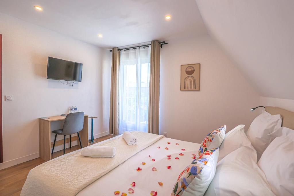 MontebourgにあるLa Villa Cassinne Chambres Indépendantesのベッドと机とテレビのある寝室