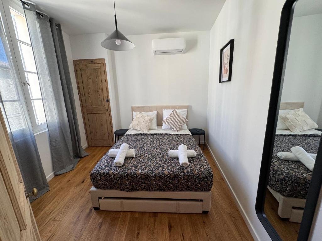 une chambre avec un lit avec deux serviettes dessus dans l'établissement Élégance & confort -2 chambres hyper centre, Clim, à Avignon