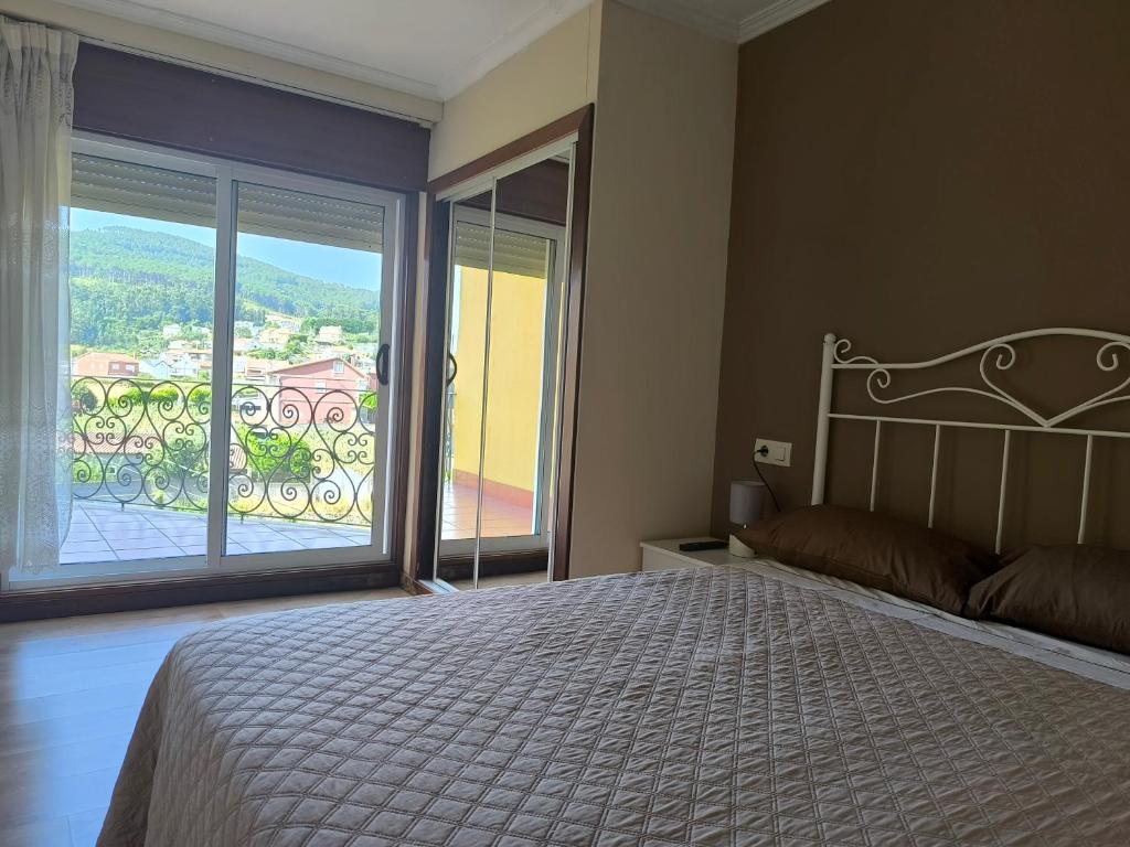 Un dormitorio con una cama grande y una ventana grande. en Camino Portugués Apartamentos, en A Guarda