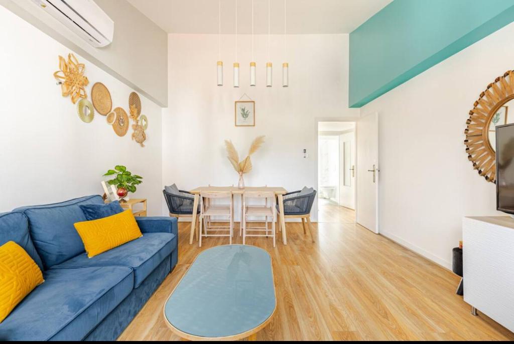 a living room with a blue couch and a table at Appart Premium Kids Friendly avec Parking Privé in Schiltigheim