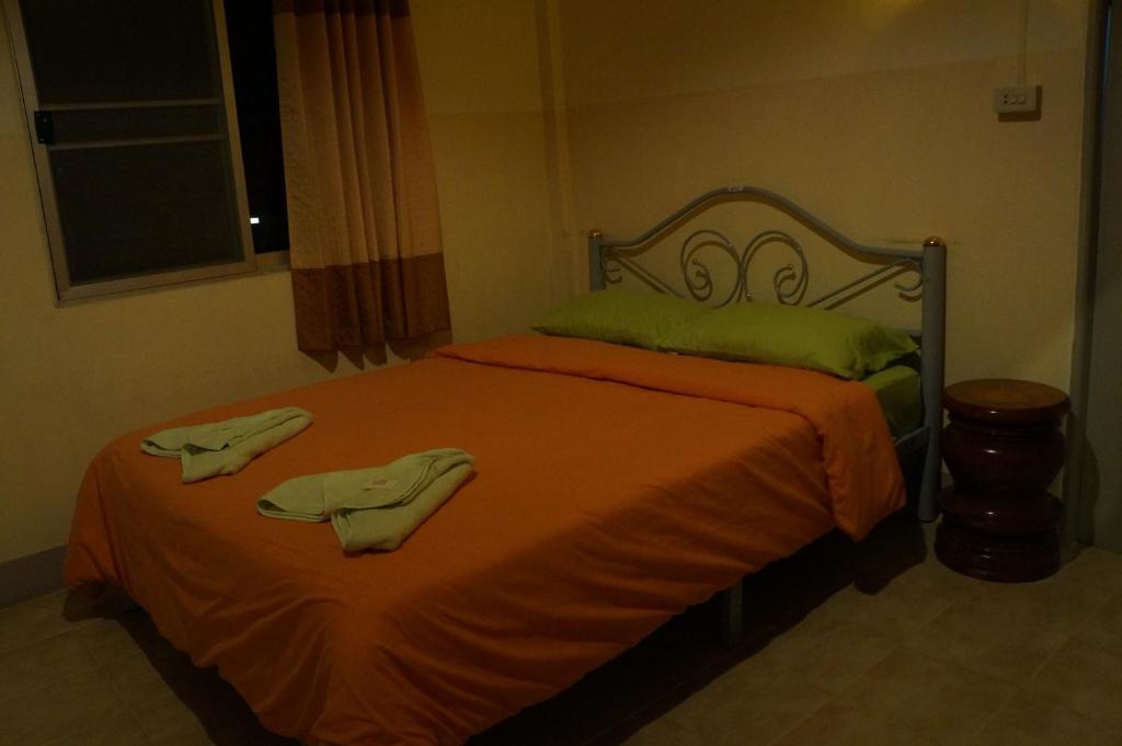 1 dormitorio con 1 cama con 2 toallas en Tanyahouse en Chiang Rai