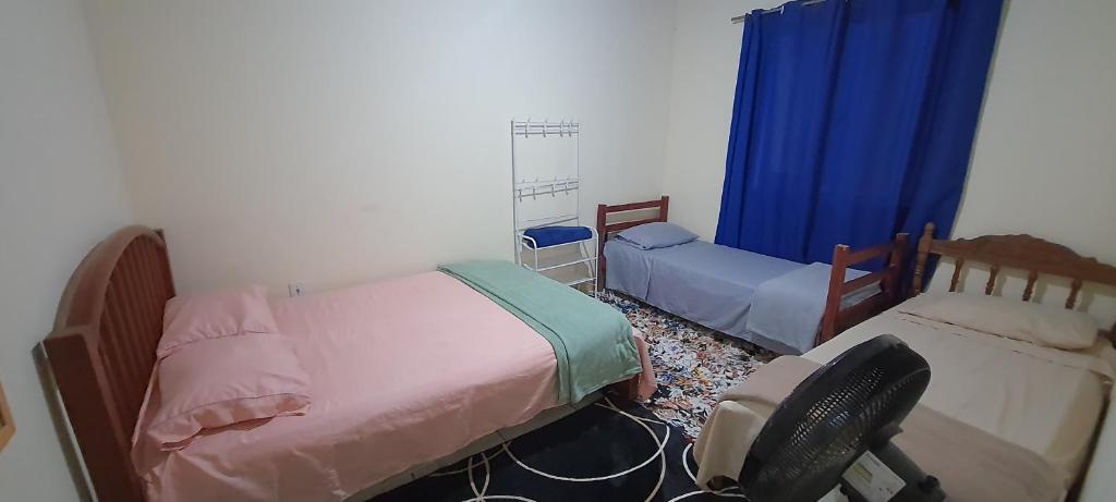 - une chambre avec 2 lits et une chaise dans l'établissement Cantinho do sossego, à Cabo Frio