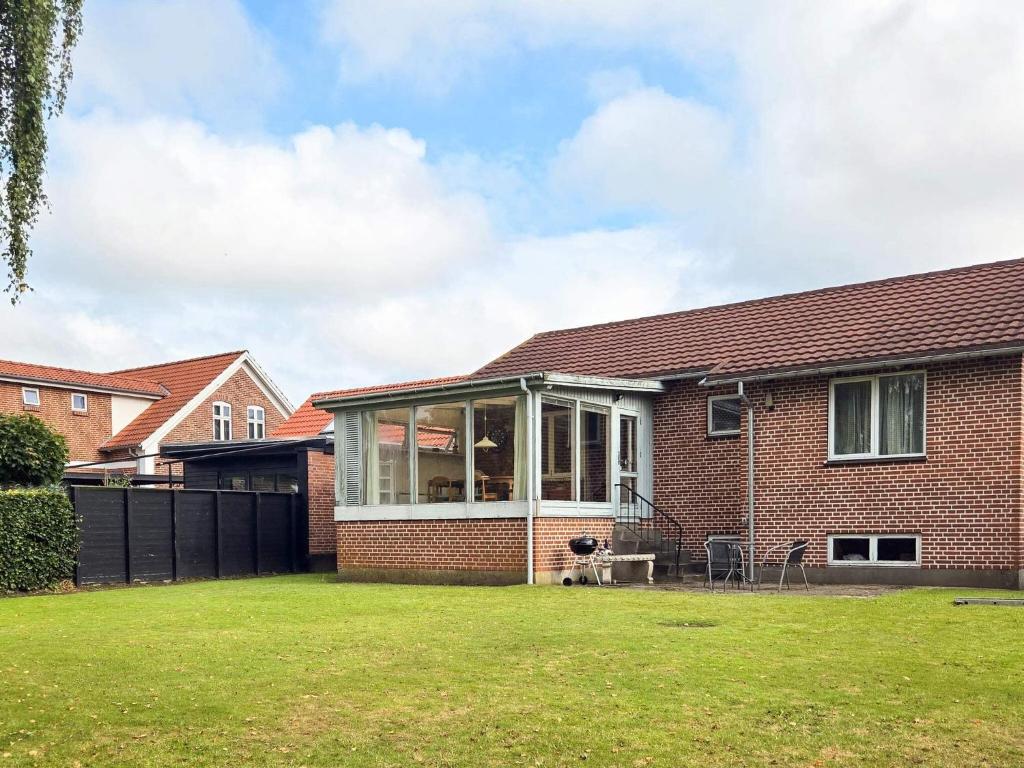 a red brick house with a large glass extension at 6 person holiday home in Ansager in Ansager