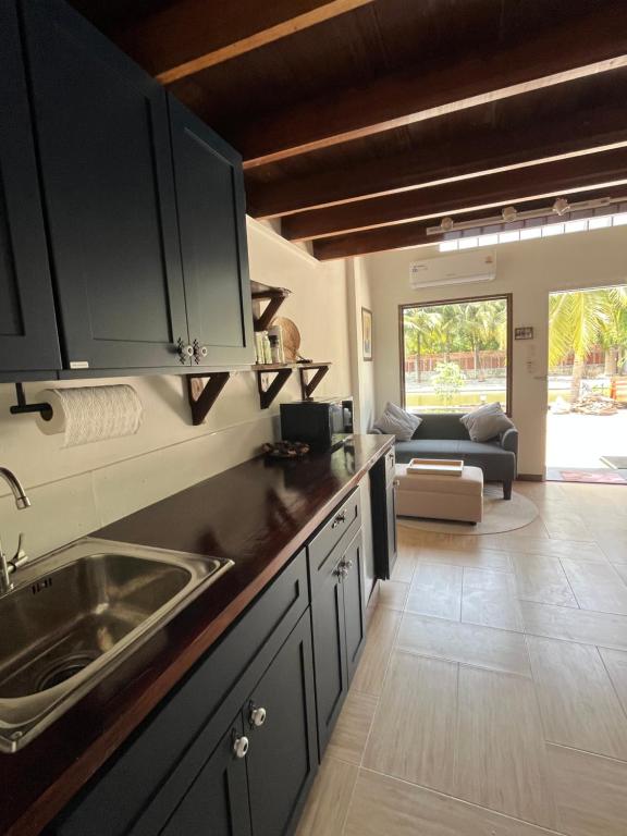 een keuken met een spoelbak en een woonkamer bij Phimai Pond House in Phimai