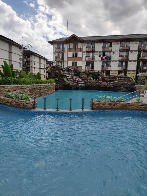 une grande piscine d'eau devant les bâtiments dans l'établissement Ica JM Nest at Hacienda Balai, à Manille