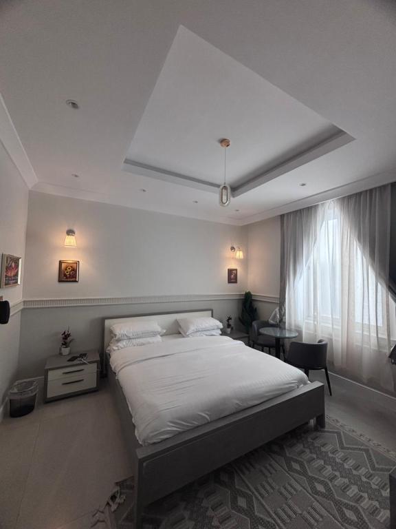 Un dormitorio con una cama blanca grande y una ventana en Modern studio, en Yeda