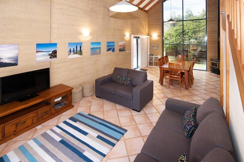 a living room with a couch and a tv at Tresco, Town central-beach end in Dunsborough
