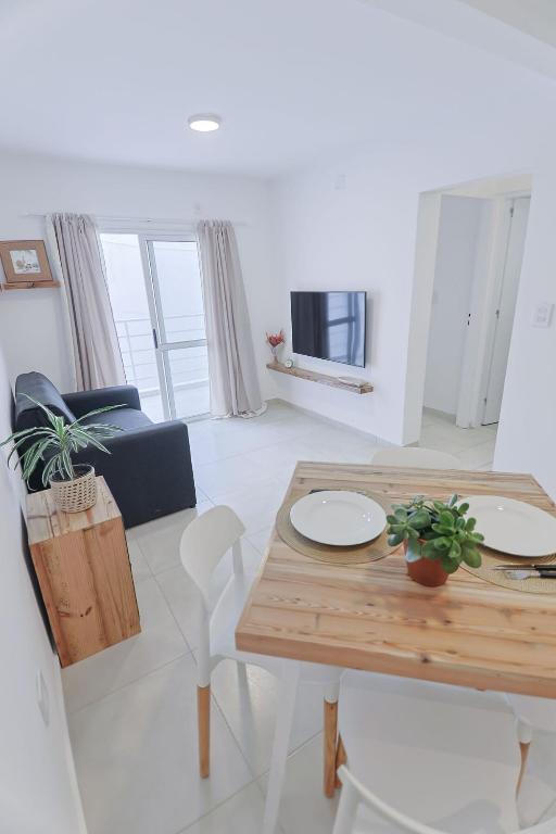 a white living room with a wooden table and chairs at Dpto Belgrano II - Santa Fe in Santa Fe