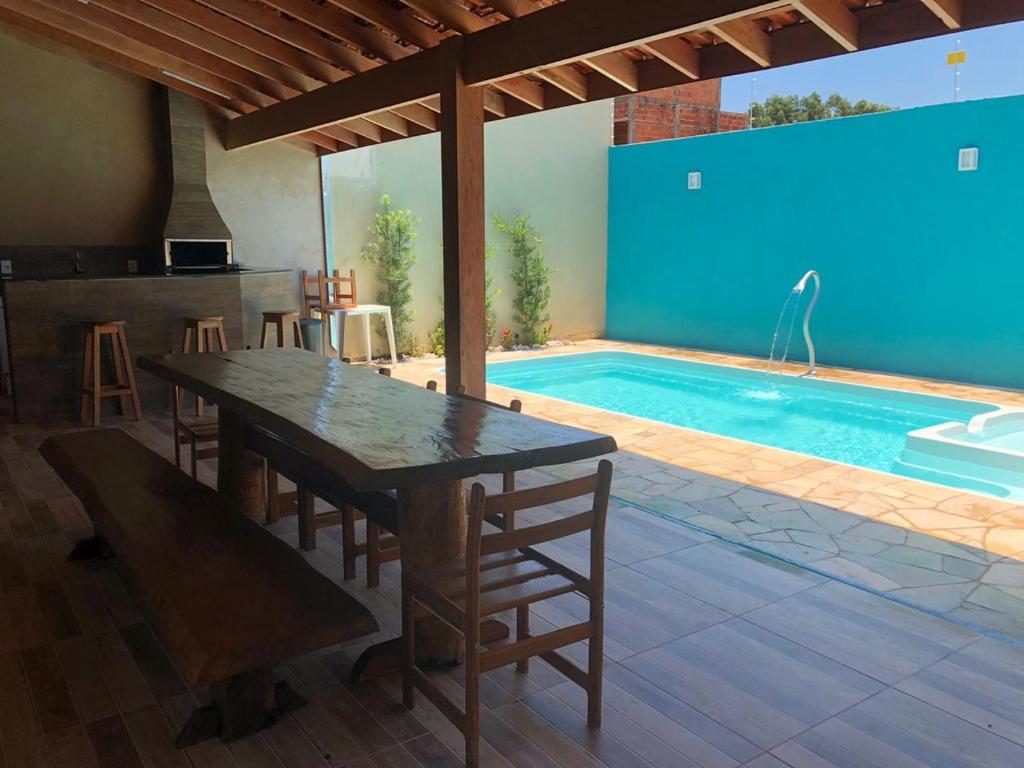 a patio with a table and a swimming pool at Recanto Julia in Olímpia