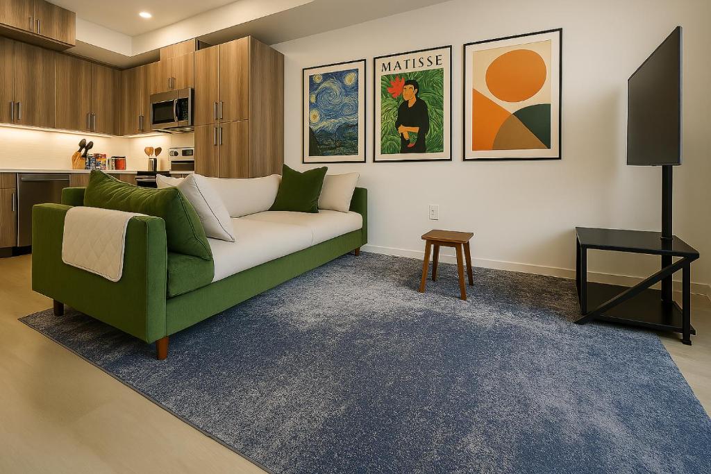 a living room with a green couch and a table at Zen Den at Ciph Lab, Eco-Tech, Private Room, Direct BART Access to SF in Oakland