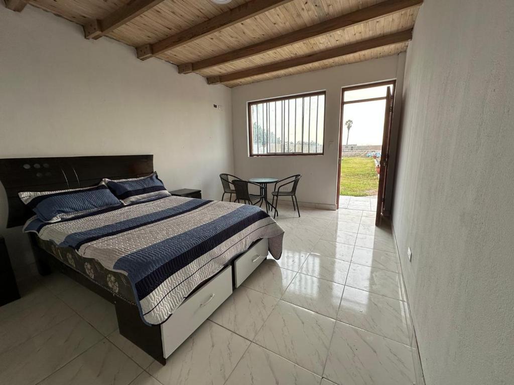 a bedroom with a bed and a table with chairs at Casa de campo relax y piscina in Cerro Azul