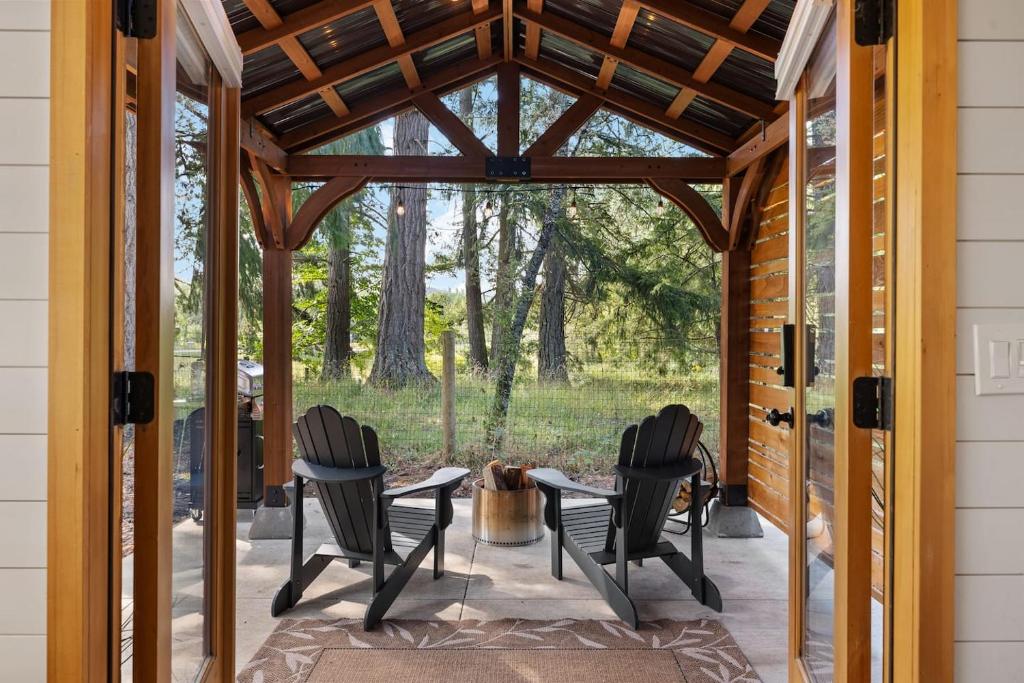 a screened in porch with chairs and a table at Eco Friendly Tiny Container Home Retreat in Camas