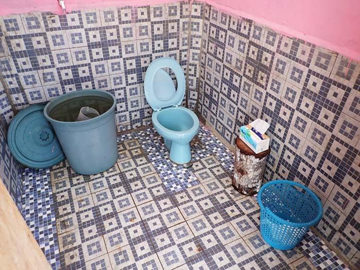 a bathroom with a blue toilet and two buckets at Homestay Yenbeyar Raja Ampat in Yariffi
