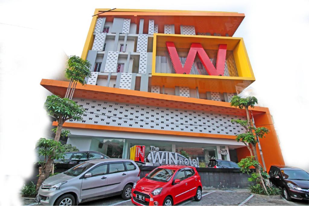 un edificio con coches estacionados frente a él en The Win Hotel Surabaya, en Surabaya