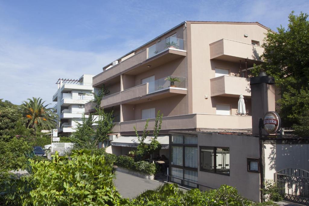 斯普利特的住宿－拉娜旅館，公寓大楼设有阳台和树木