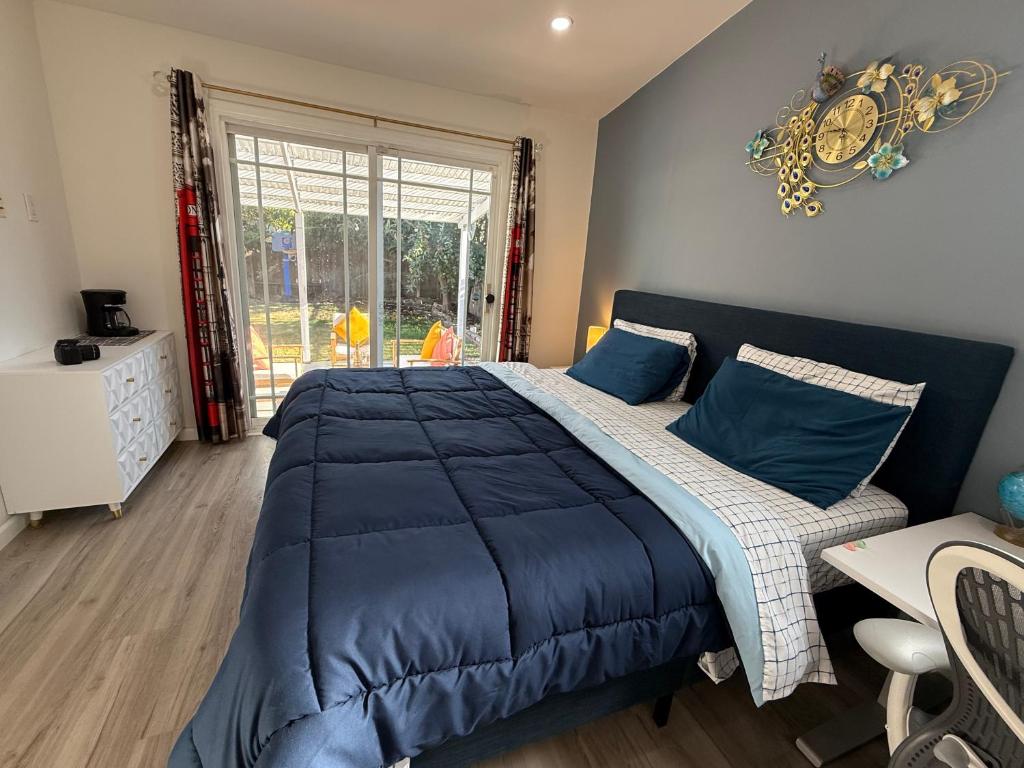 une chambre avec un lit bleu et une fenêtre dans l'établissement Private Master Suite with workplace, & OutdoorSitting, à San Mateo