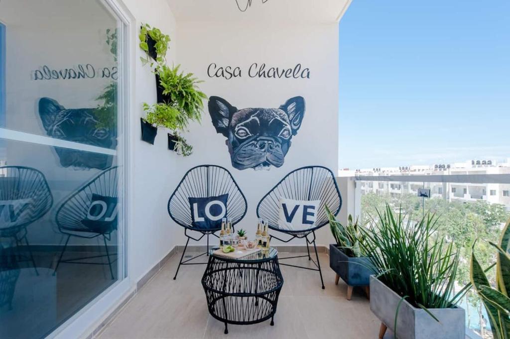 a room with chairs and a table with a sign on the wall at Casa Chavela10 Min Beach, Wifi 500 Mb, Gym, Pools in Playa del Carmen