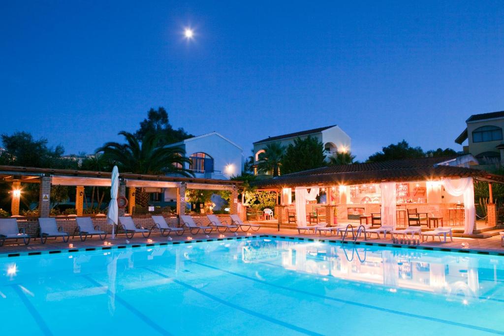 una piscina con sedie e un hotel di notte di Gouvia - Luxury Suite a Gouviá