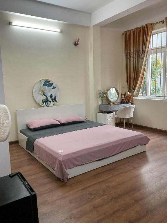 a bedroom with a large bed and a desk at Ribi Home in Hà Ðông