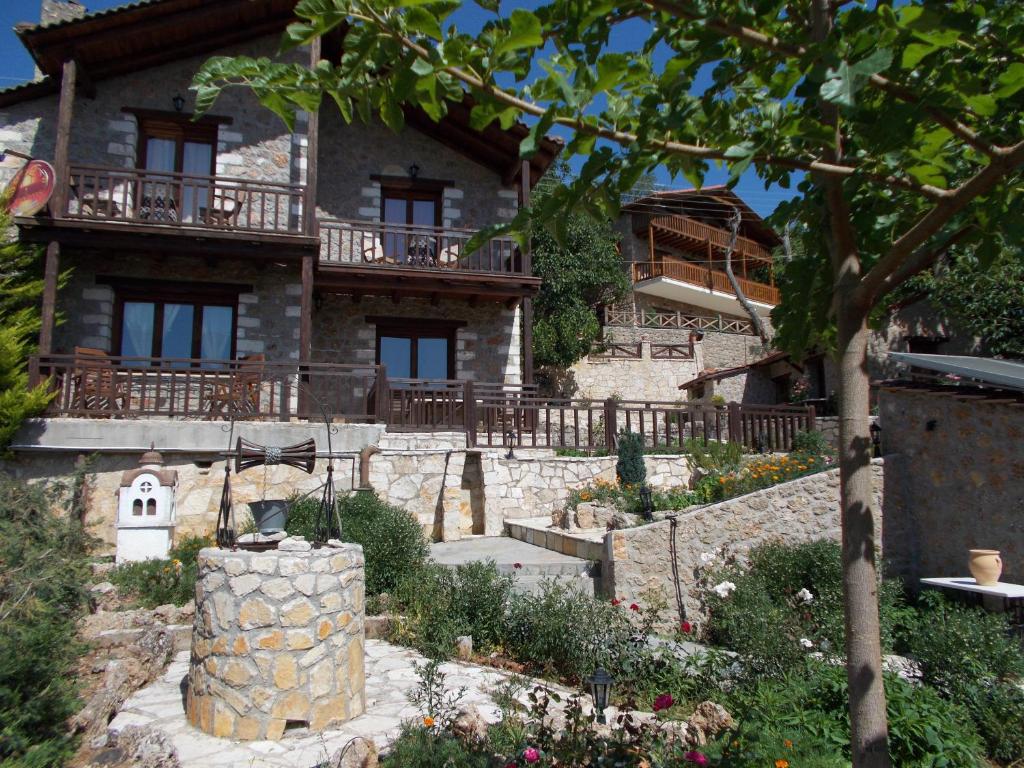 an old house with a garden in front of it at Theasis suites-Ορεινή Φιλοξενία in Kato Trikala Korinthias