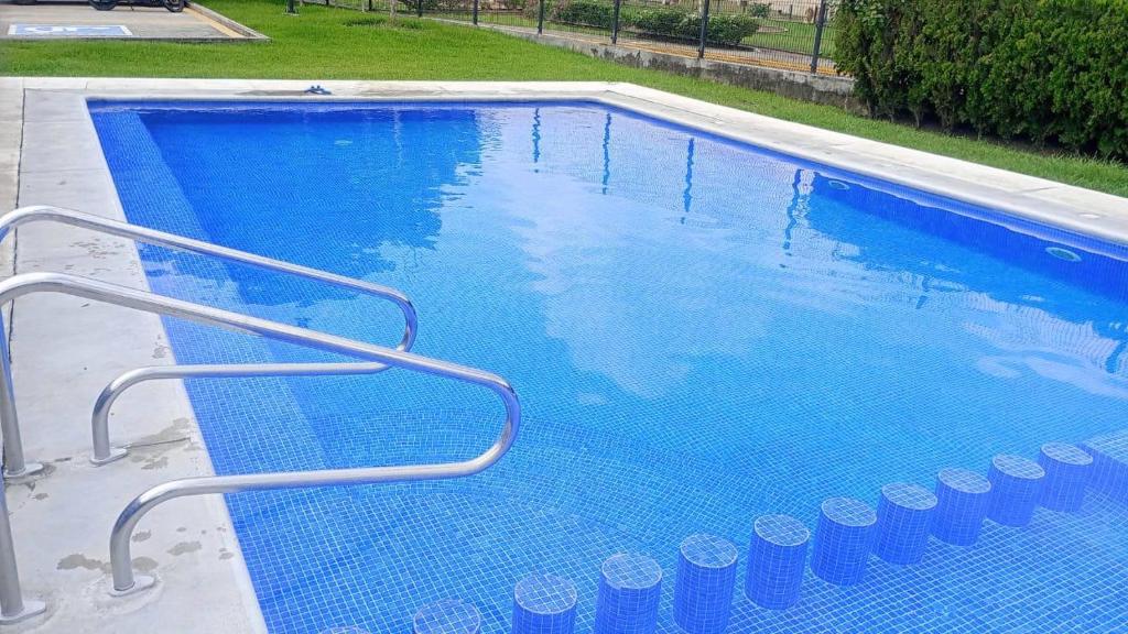 a large blue swimming pool with blue water at La escondida del mar in Valente Díaz y La Loma