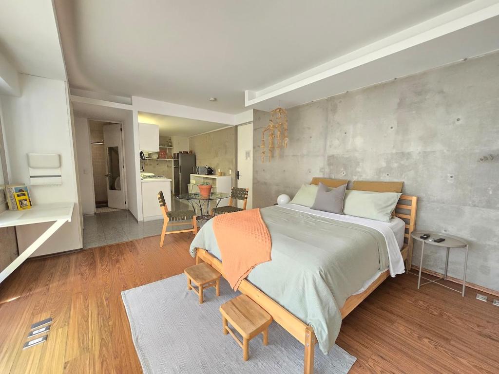 a bedroom with a large bed and a dining room at Cute Condesa Studio Indoor Pool Nice Gym in Mexico City