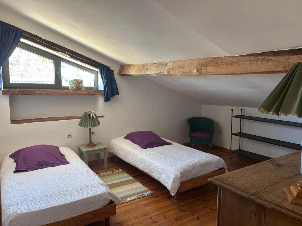 Un dormitorio con dos camas y una ventana. en Domaine Le Rolant, en Montaut