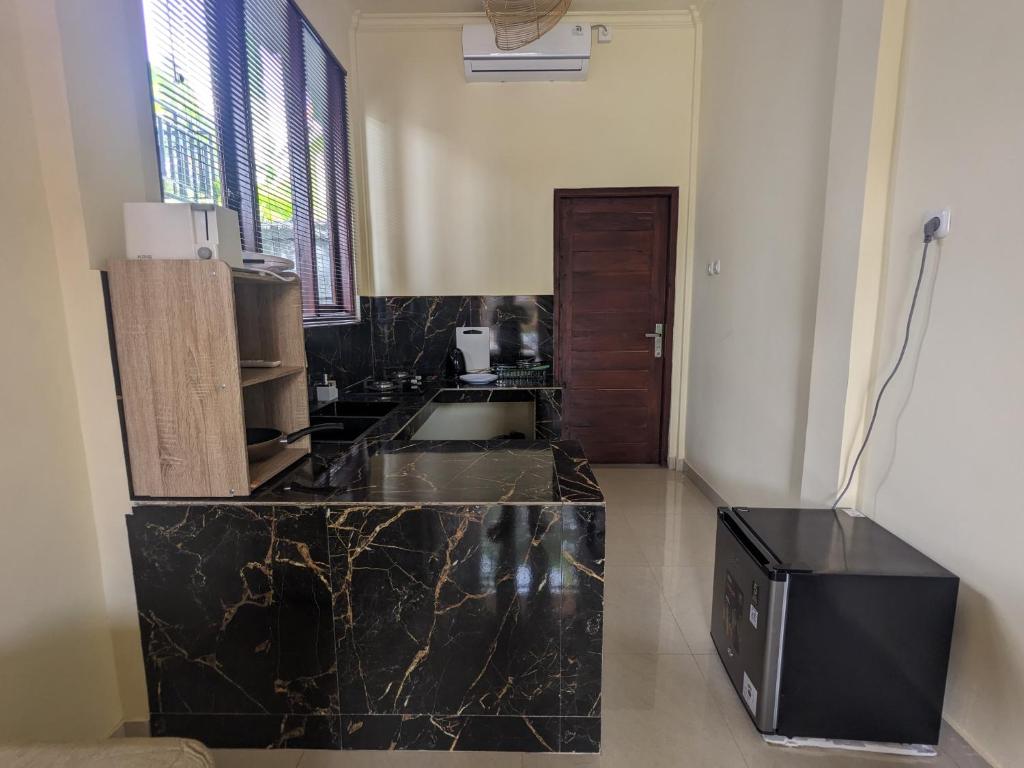 eine Küche mit einer schwarzen Arbeitsplatte in einem Raum in der Unterkunft Stellar Cottage Lovina- a villa in Murni's house in Lovina