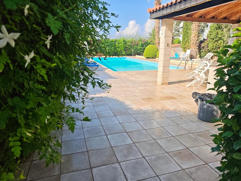 a patio with a swimming pool in a yard at Sunset Green 01 in Paphos City