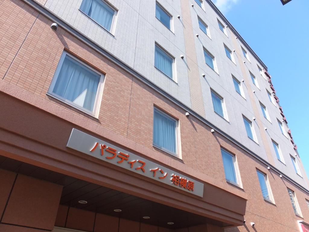 a building with a sign on the side of it at Paradis Inn Sagamihara in Sagamihara