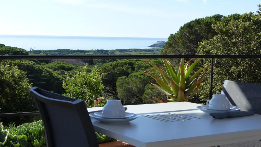 a white table and chairs with a view of the ocean at Hôtel les Bouis - Vue mer in Saint-Tropez