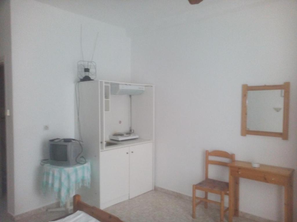 kuchnia z lodówką, krzesłem i lustrem w obiekcie Karagiozos Studios & Apartments w mieście Skopelos