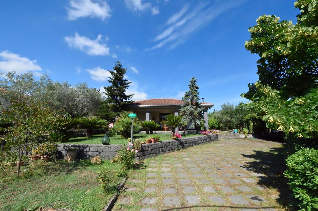 a house with a garden and a stone pathway at Etna Travellers B&B in Mascalucia