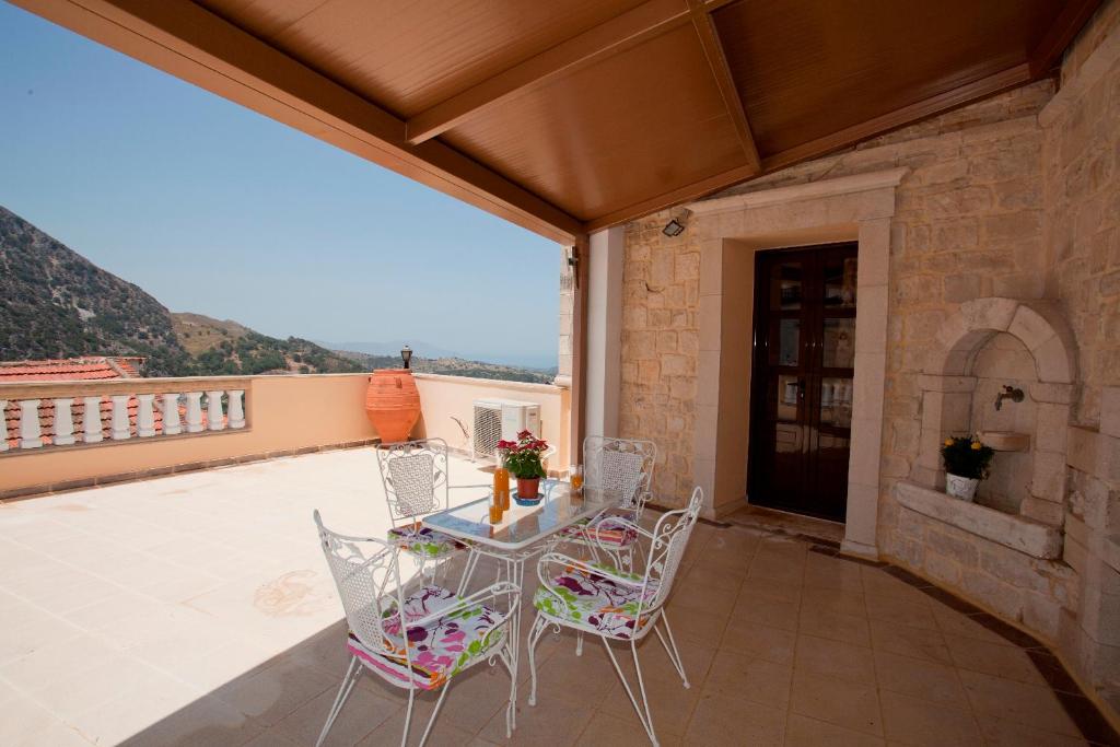 a patio with a table and chairs on a balcony at Erontas in Aryiroúpolis