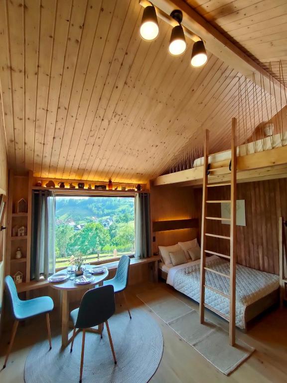 a bedroom with a bunk bed and a table and chairs at Echo Magura in Măgura