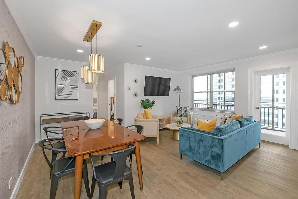 a living room with a blue couch and a table at Stayatl Premier 2 Bed Condo W Views! in Atlanta