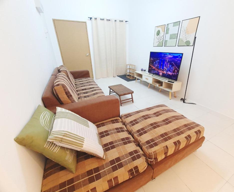 ein Wohnzimmer mit Sofa und Fernseher in der Unterkunft Emilie 164 Cozy Seremban Homestay Galena Seremban Town in Seremban