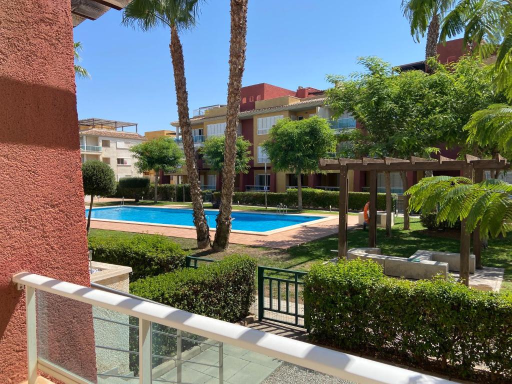 a resort with a swimming pool and palm trees at Apartamento en Hacienda del Alamo enfrente de la Piscina! in Fuente-Álamo de Murcia