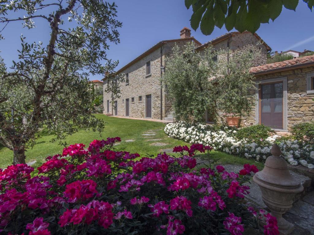 un giardino fiorito di fronte a un edificio di Maestà Del Sasso a Cortona