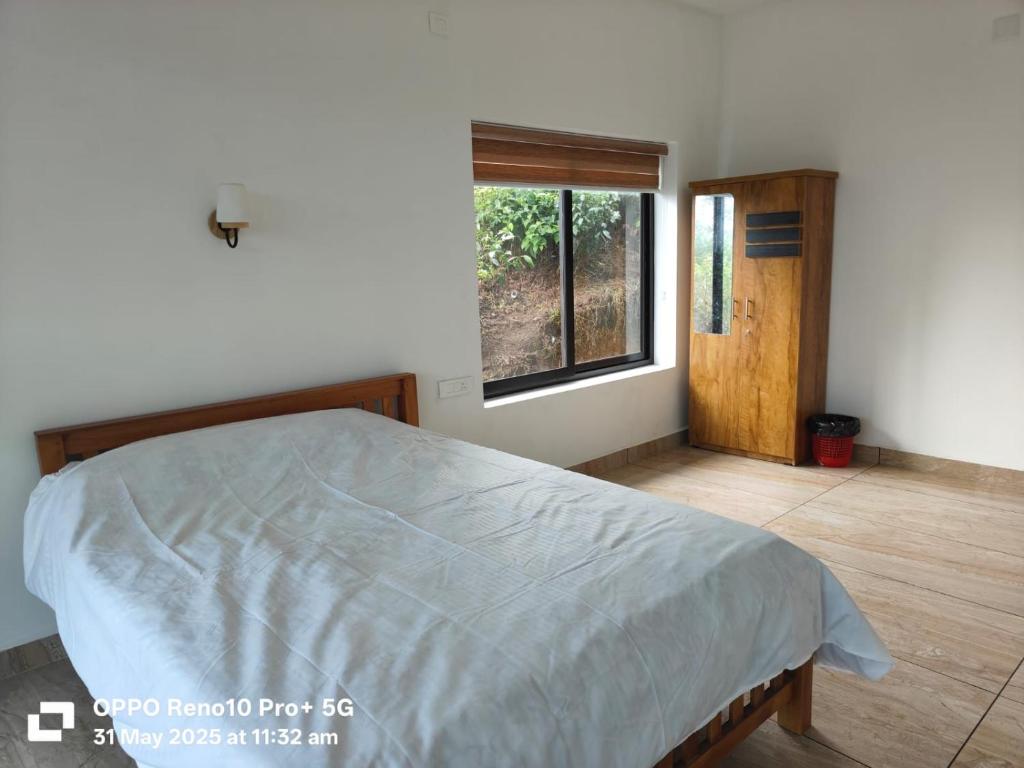 Un dormitorio con una cama grande con ventana. en Magic Destination, en Vagamon