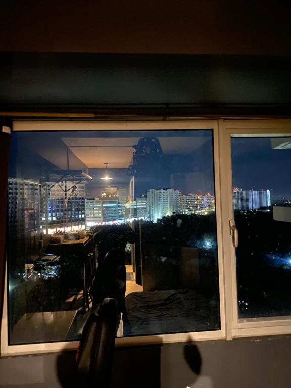 een raam met uitzicht op de stad 's nachts bij Urban solace iloilo in Iloilo City
