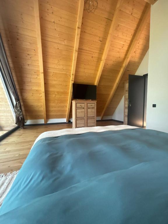 a bedroom with a large bed and wooden ceilings at MikeHaus in Beliş