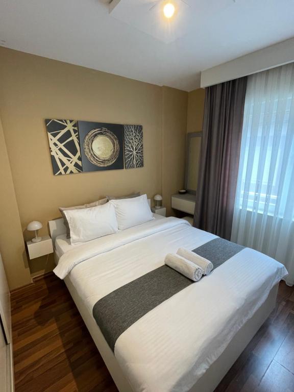 a bedroom with a large bed with two towels on it at Bluberry Apartment in Pristina