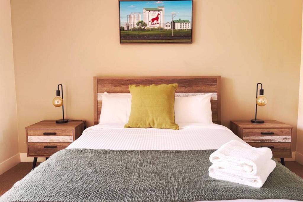 a bedroom with a large bed with a yellow pillow at Rooftops On Henrycentre Of West End Cafes in Fremantle