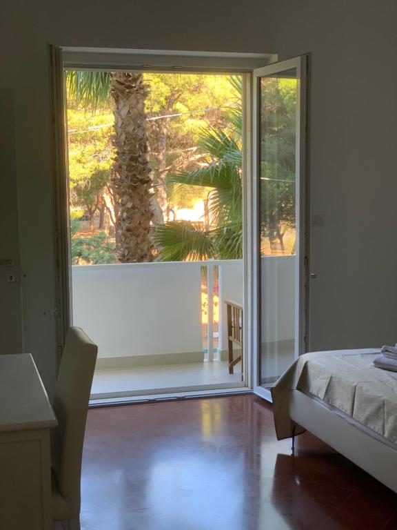a bedroom with a sliding glass door with a palm tree outside at B&B Madreperla in Gallipoli